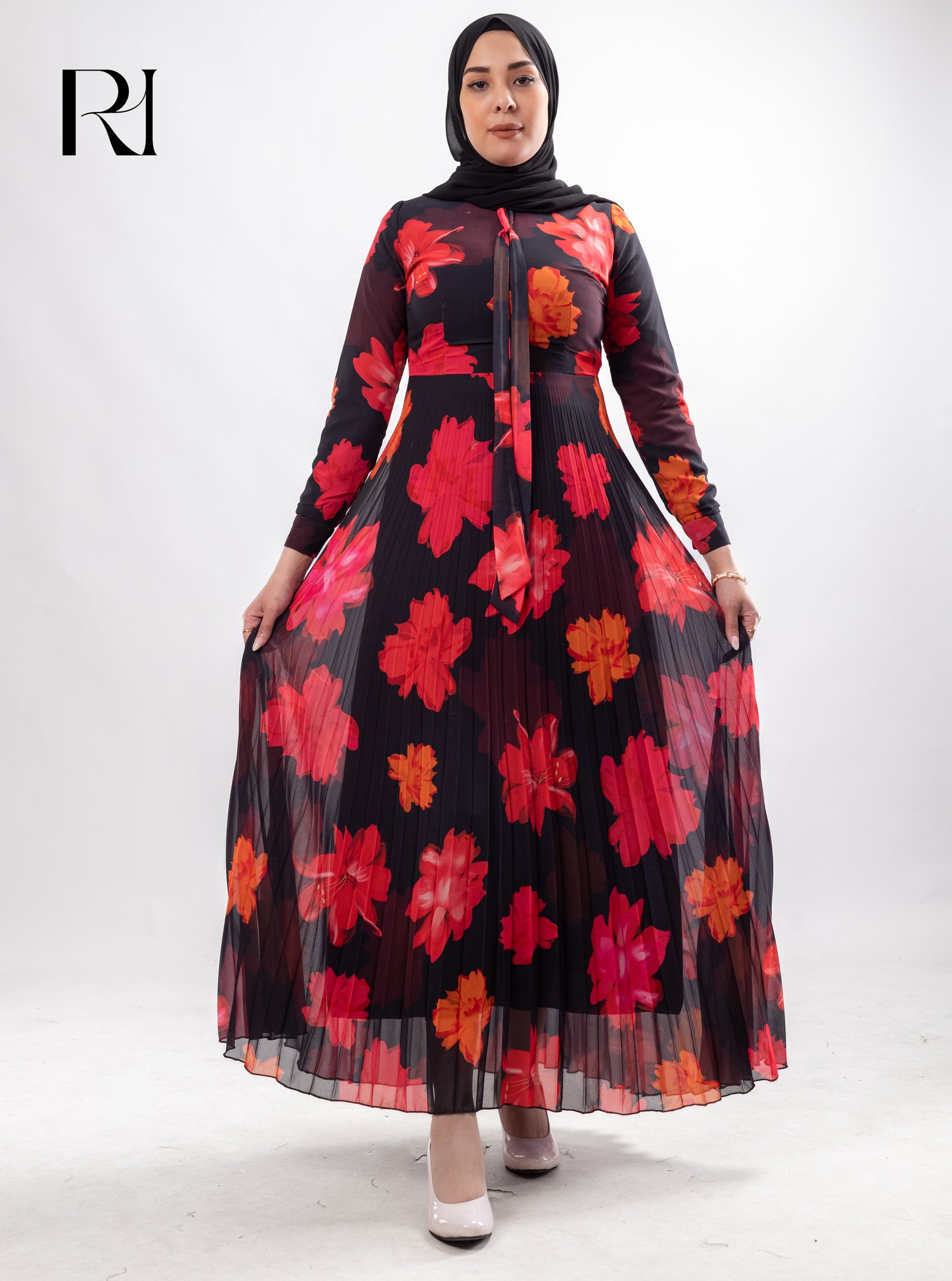 Woman wearing a black dress with red floral patterns on a white background