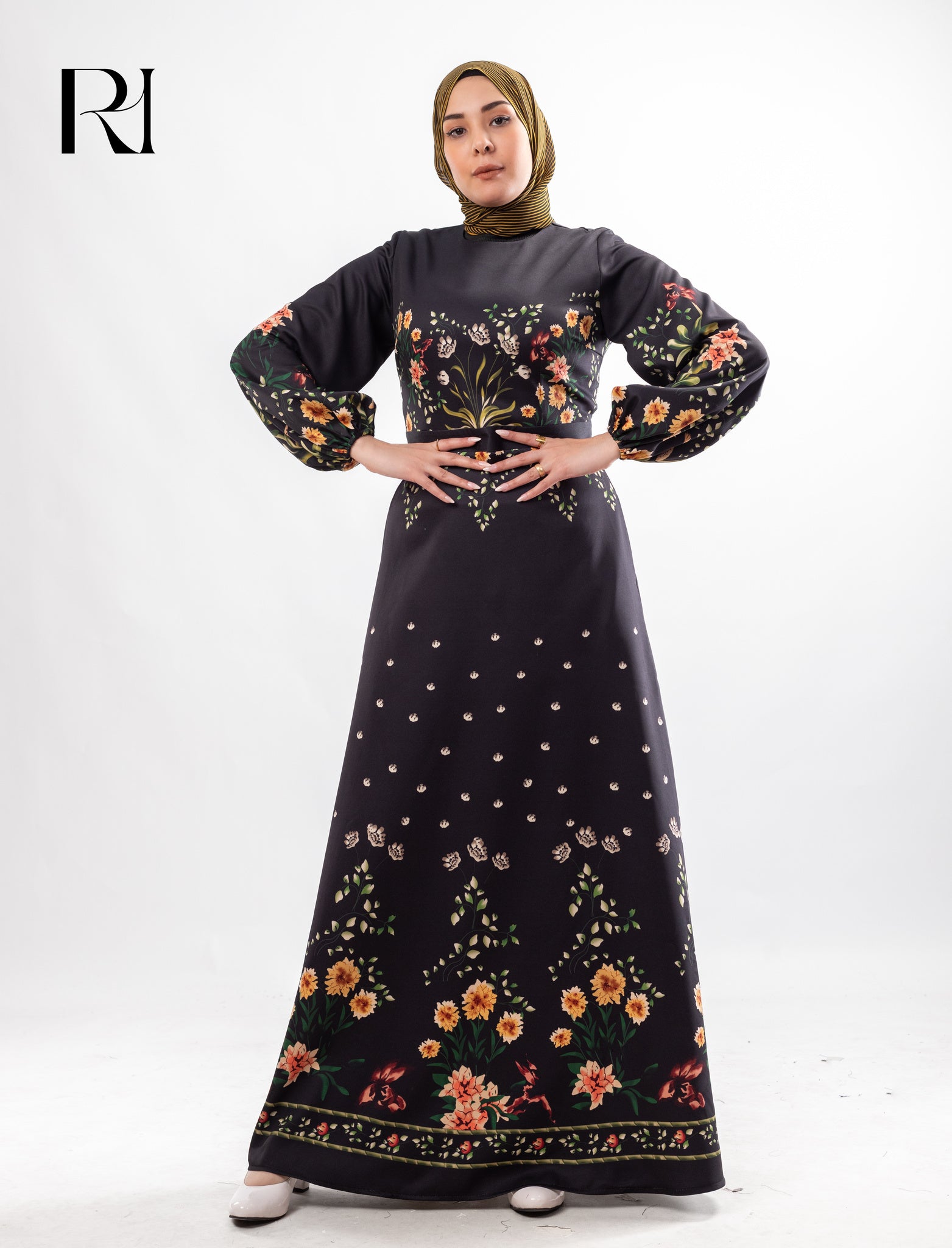 Woman wearing a black floral dress with a hijab on a white background