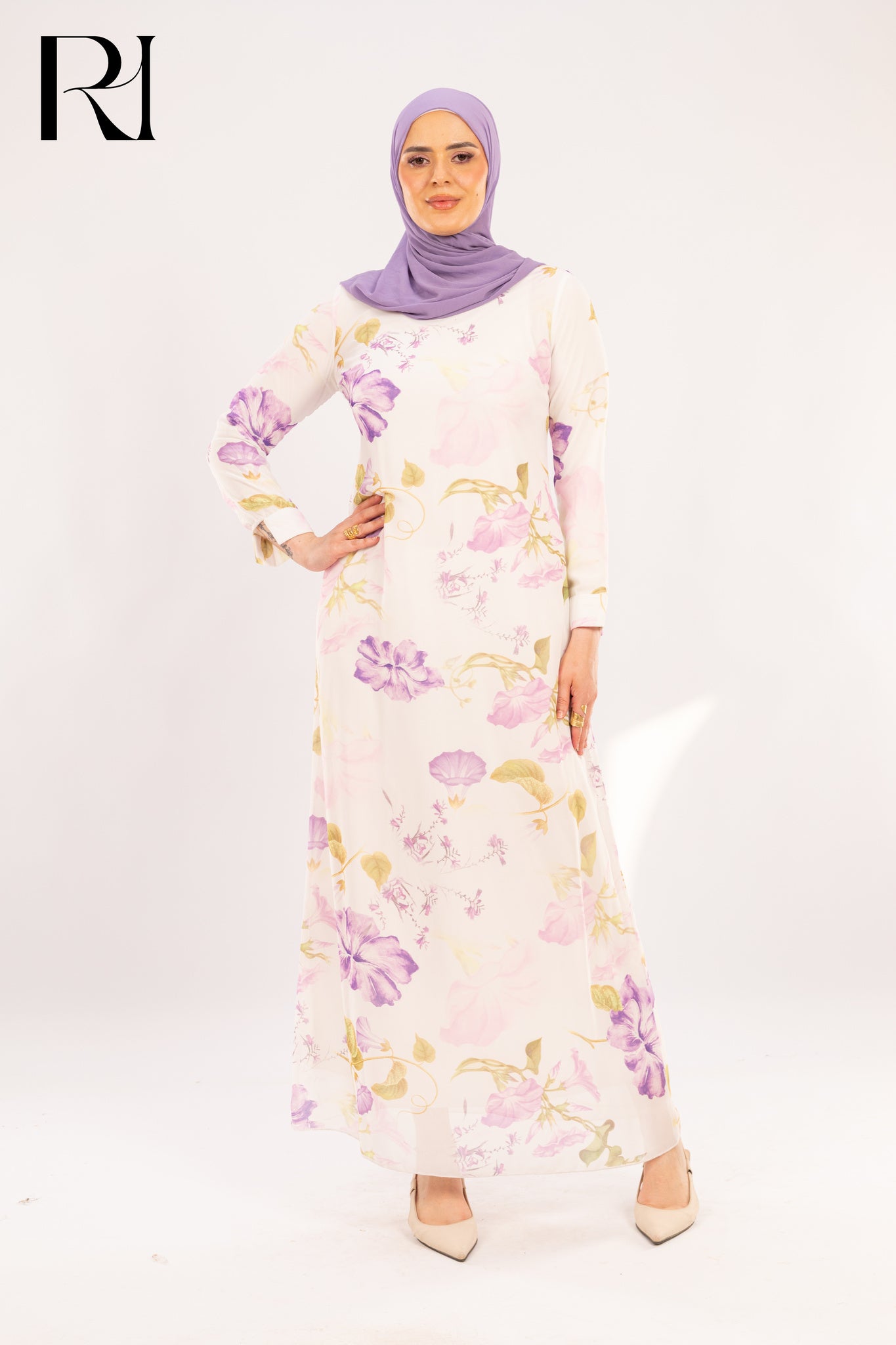 Woman wearing a floral dress and purple hijab on a white background