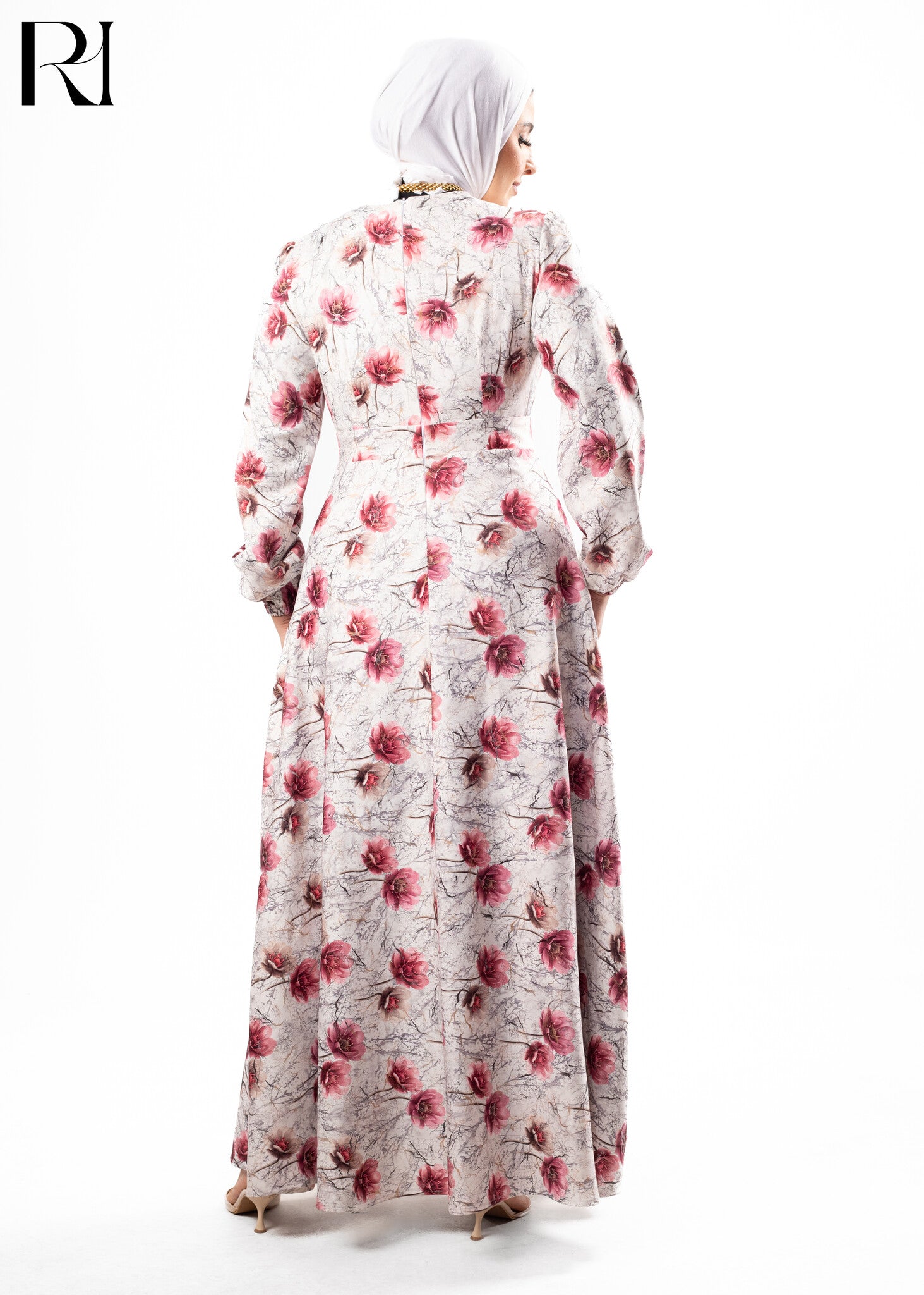 Woman wearing a floral dress with a hijab on a white background