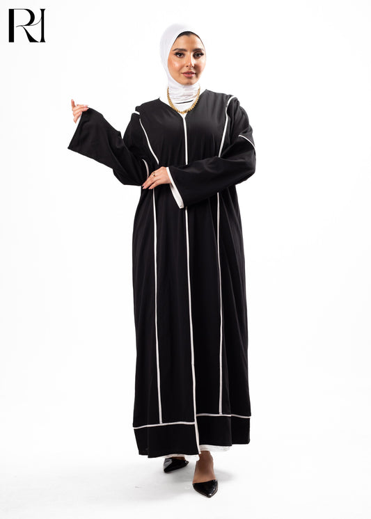 Woman wearing a black abaya with white trim on a white background