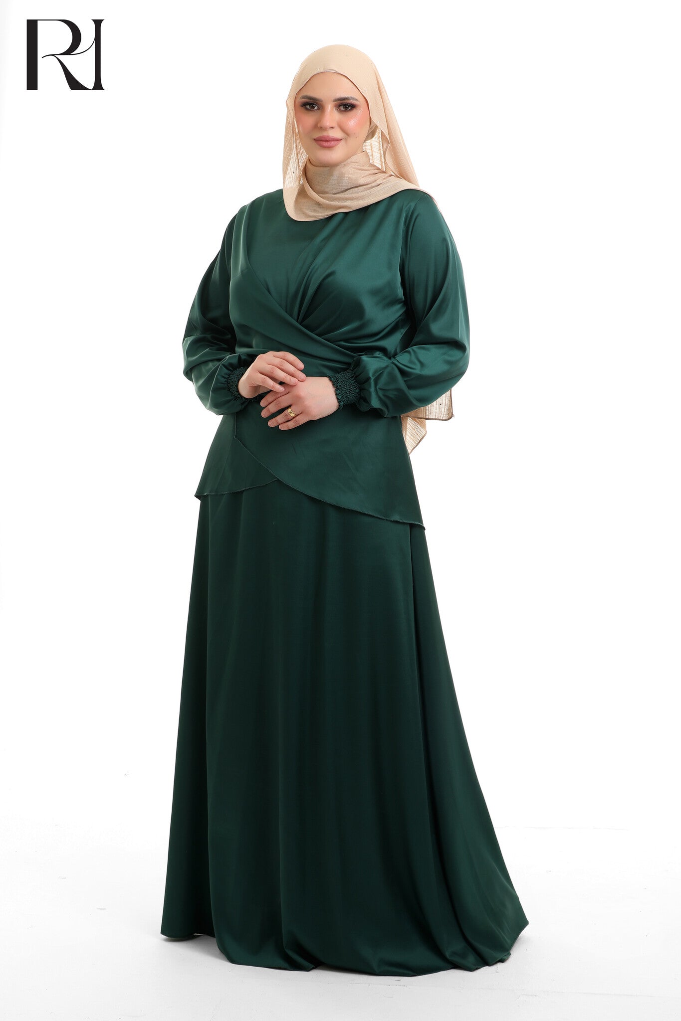 Woman wearing a green dress with a beige hijab on a white background