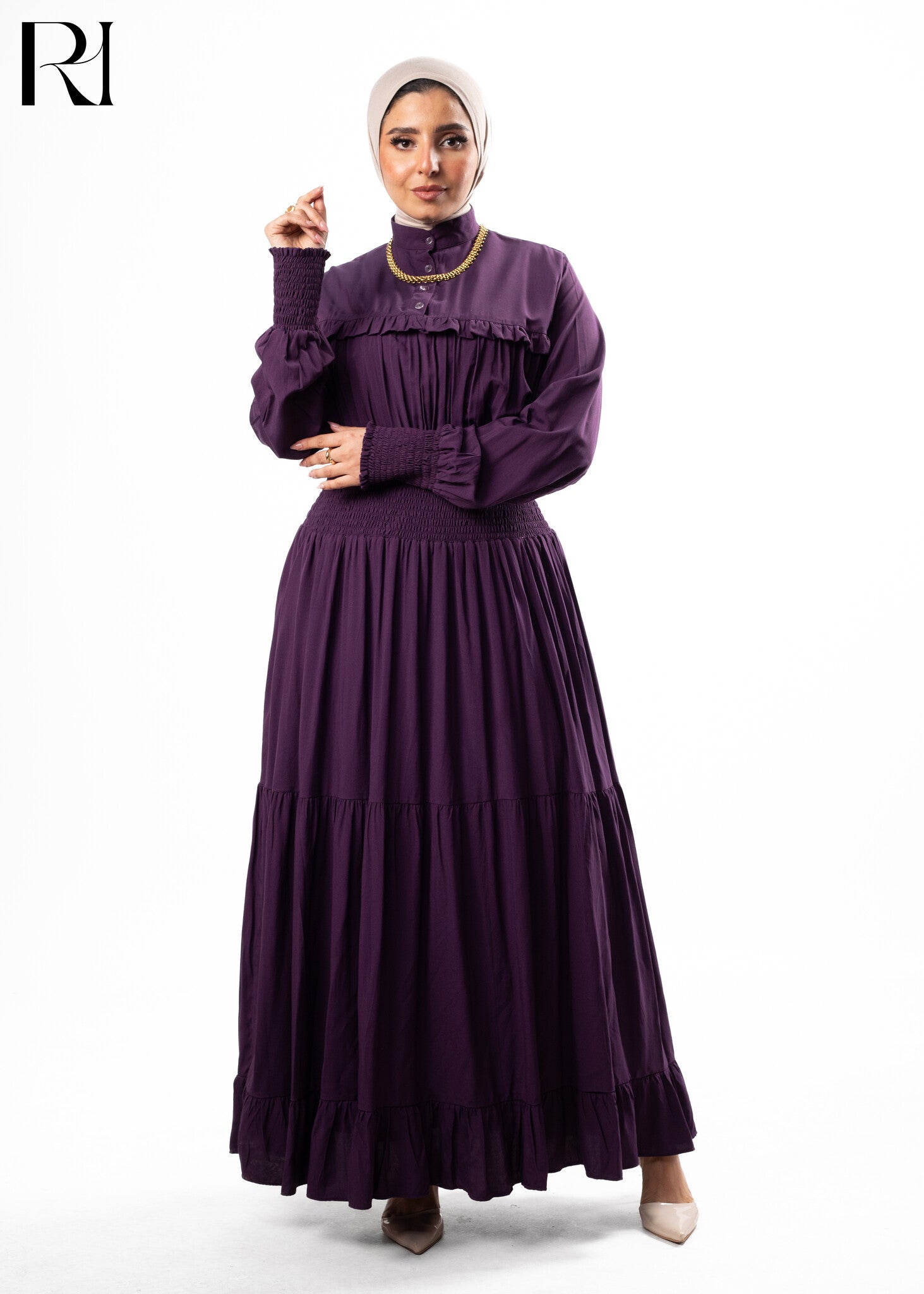 Woman wearing a long purple dress with a white background