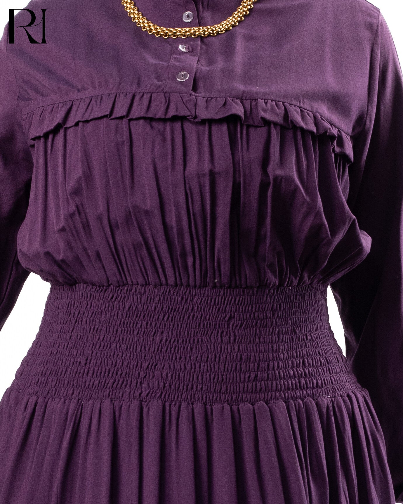 Purple dress with smocked waist and gold necklace on a white background