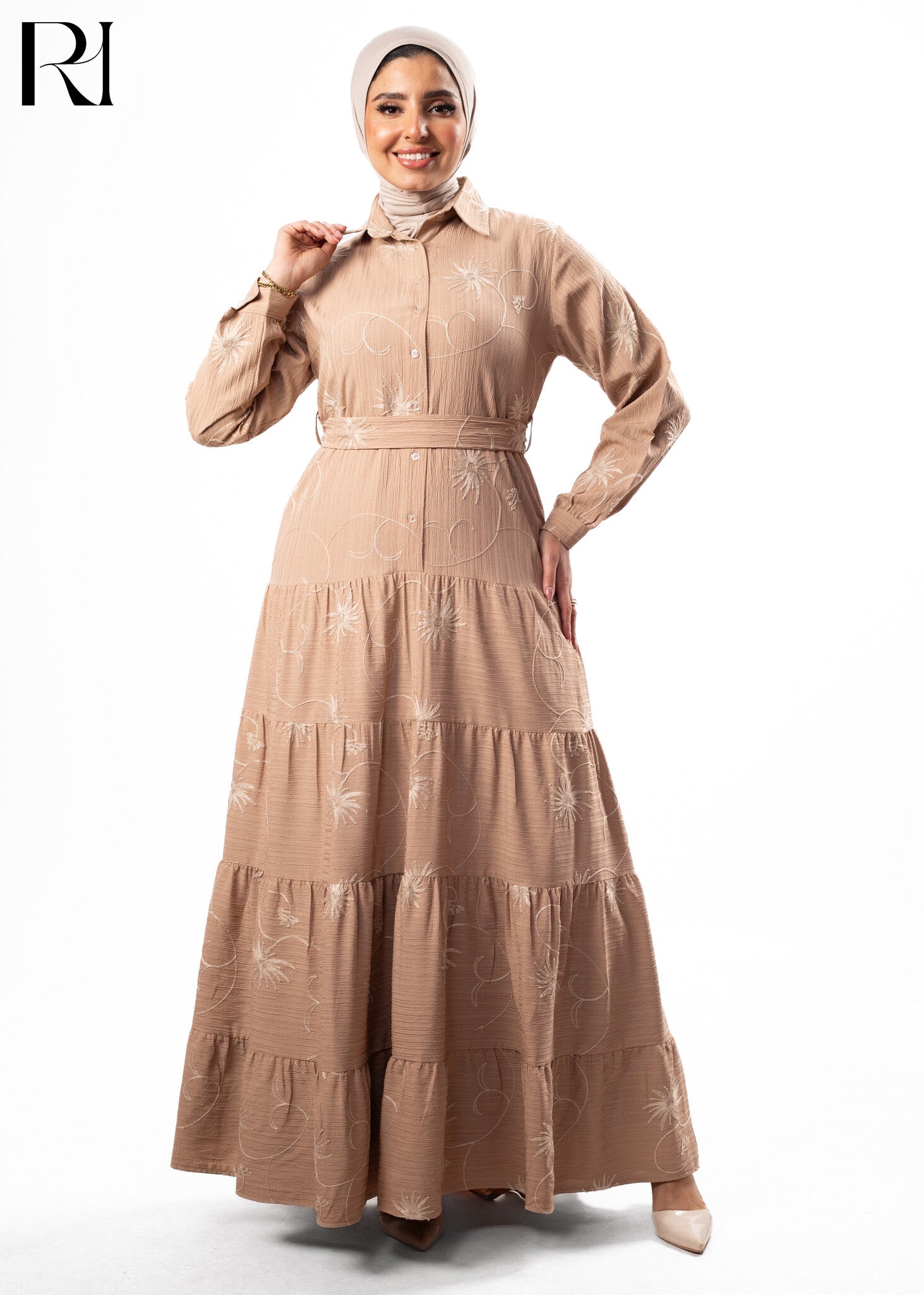 Woman wearing a beige dress with floral patterns on a white background