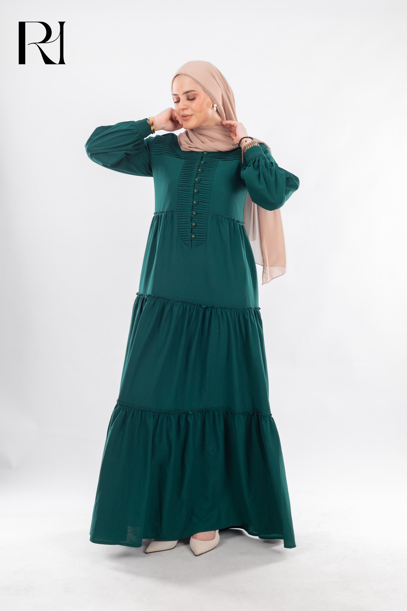 Woman wearing a green dress with a hijab on a white background