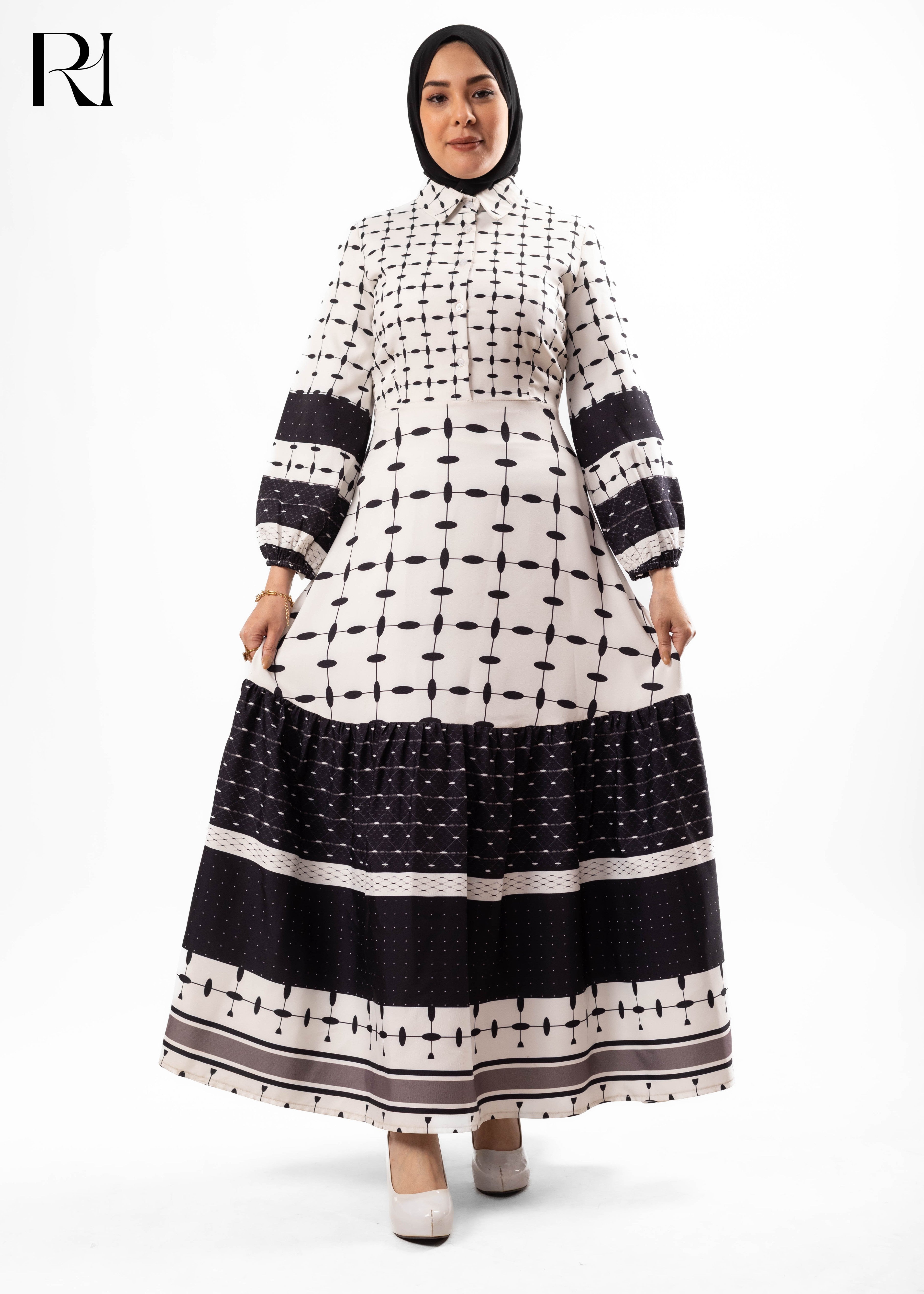 Woman wearing a black and white patterned dress on a white background