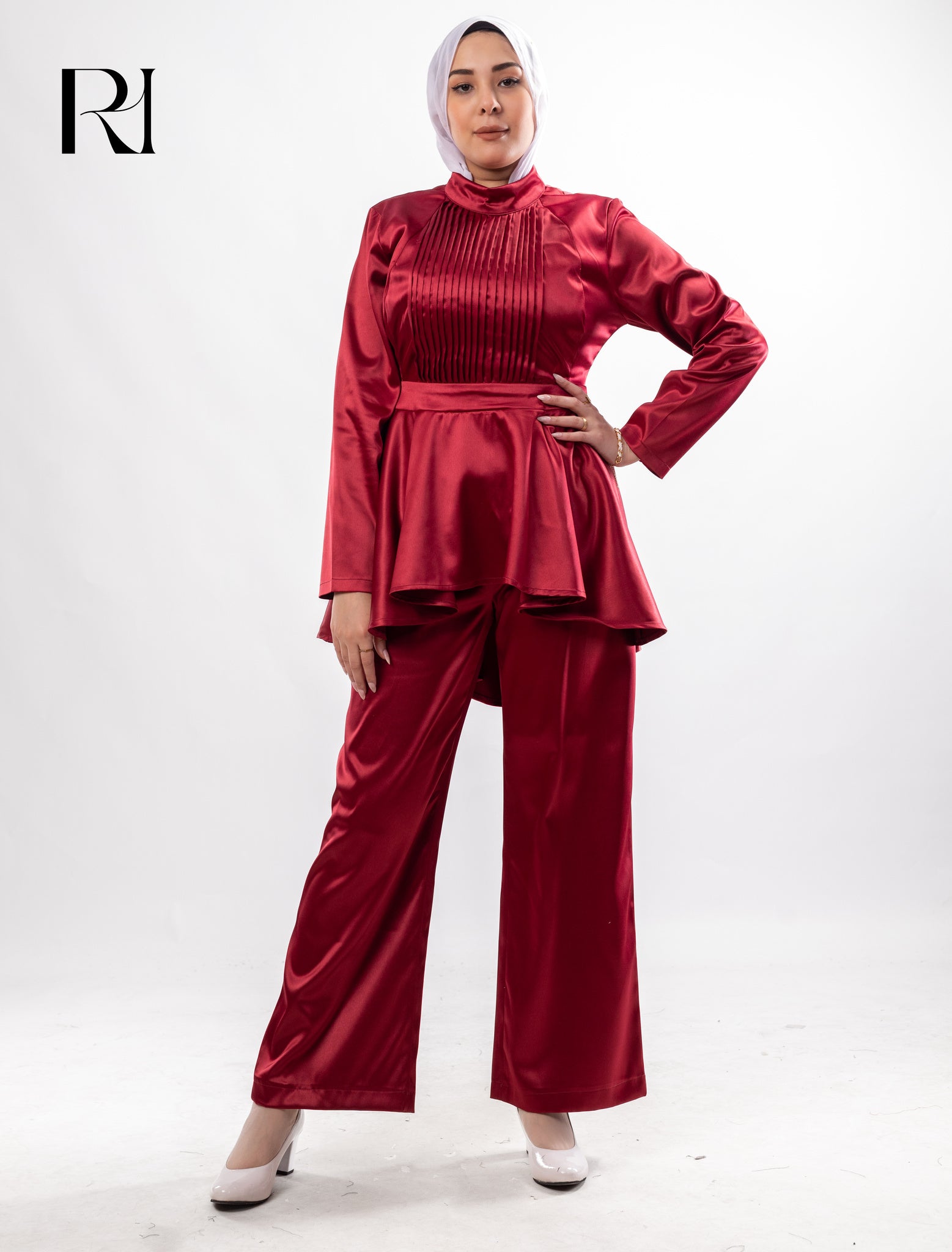 Woman wearing a red satin outfit with a hijab on a white background