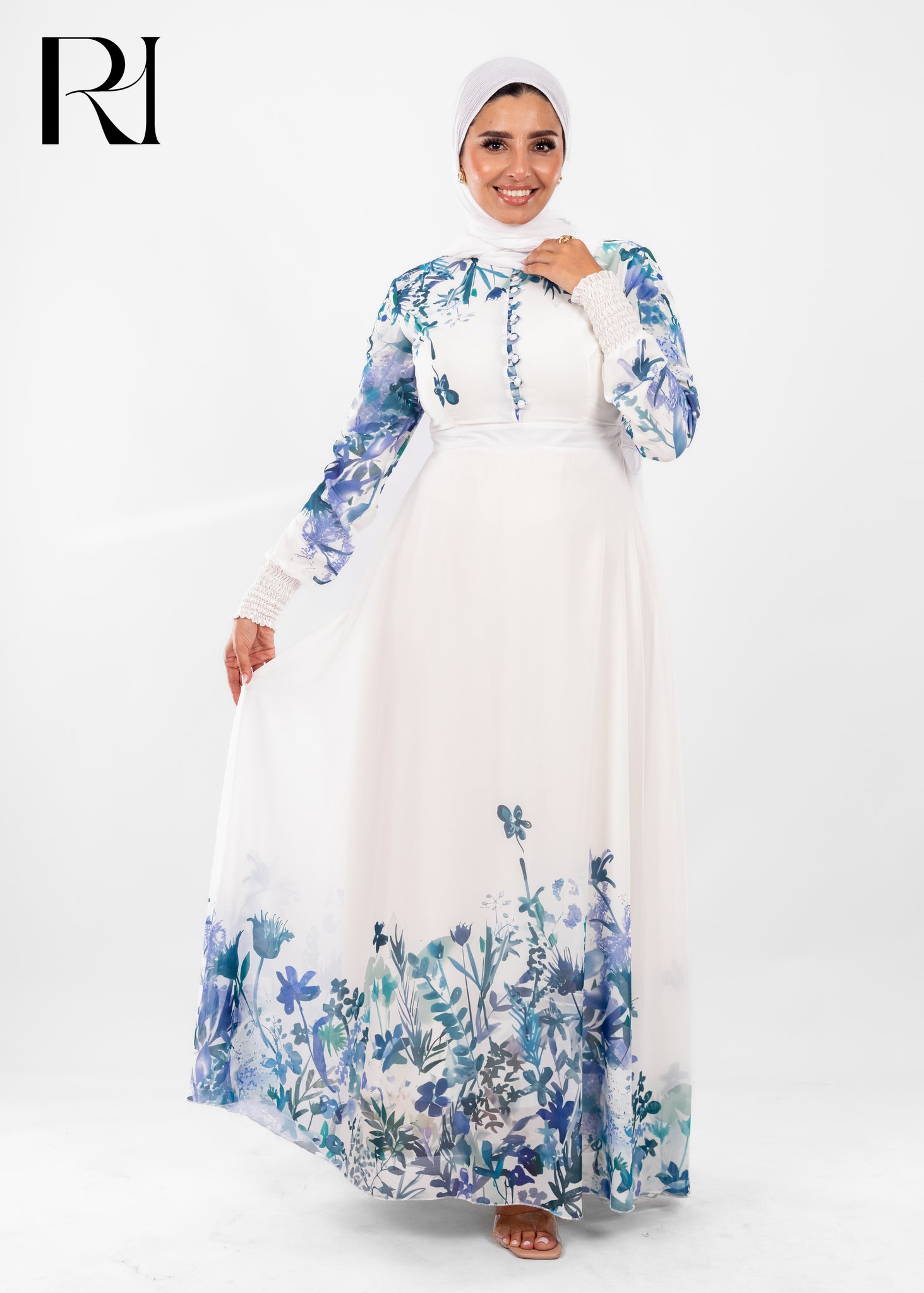 Woman wearing a white dress with blue floral patterns on a white background