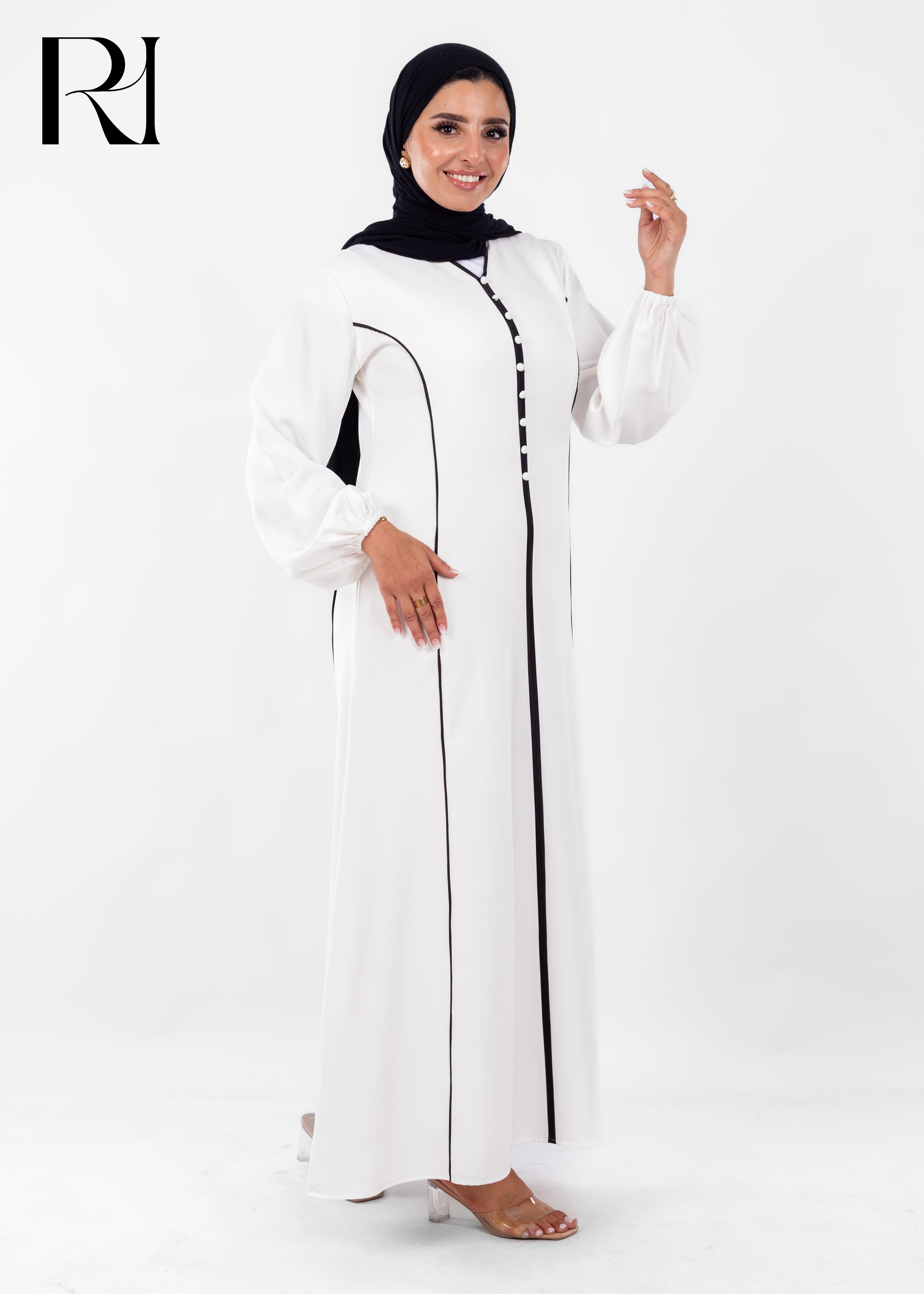 Woman wearing a white outfit with black accents on a white background, featuring the brand 'RI'.