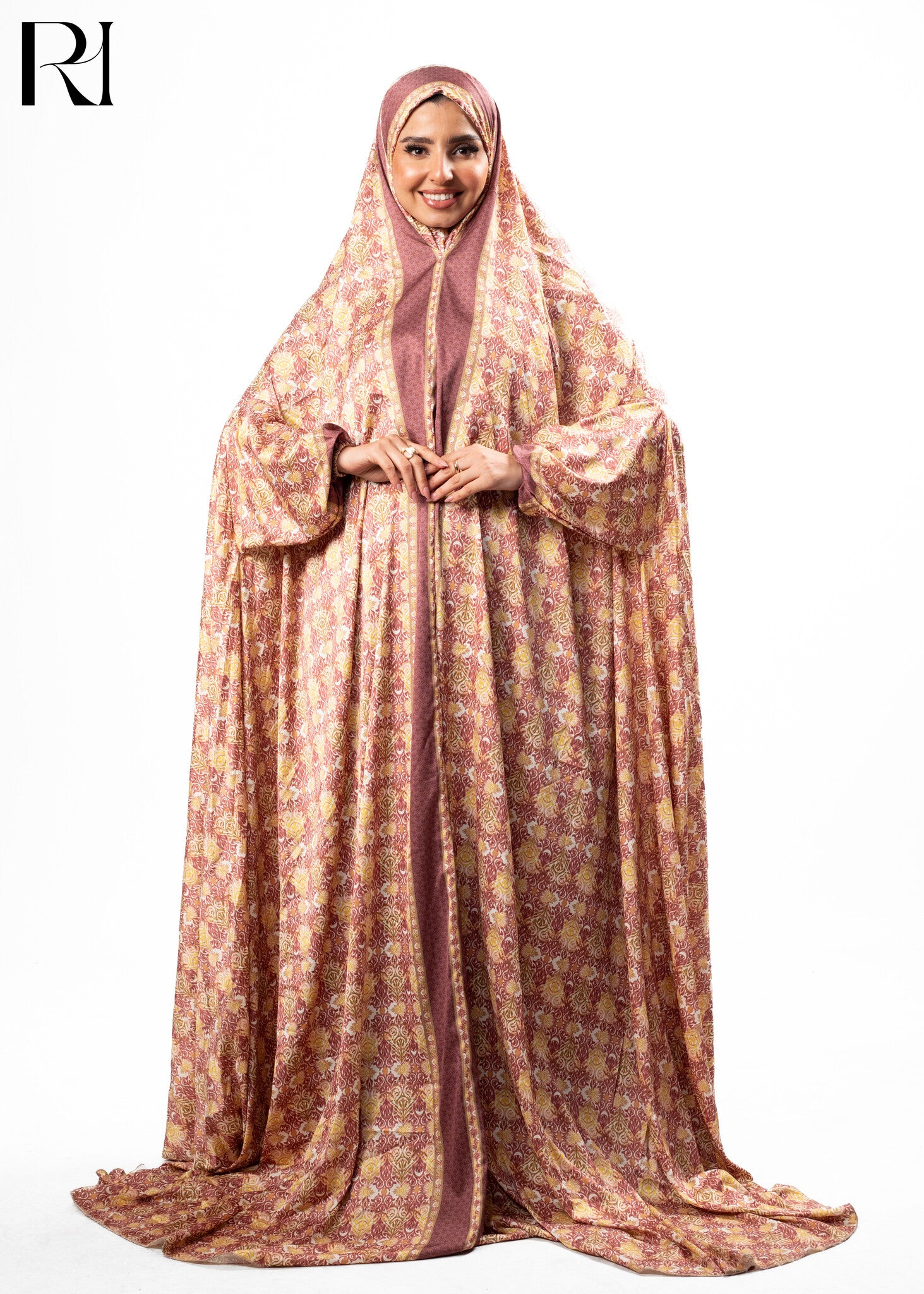 Woman wearing a long, patterned dress with a hijab on a white background