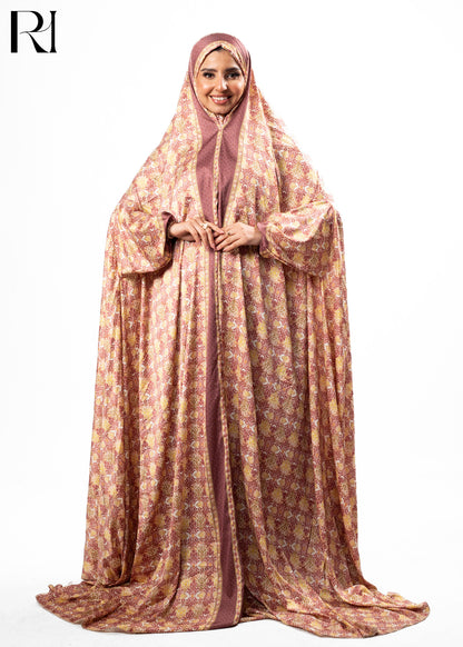 Woman wearing a long, patterned dress with a hijab on a white background