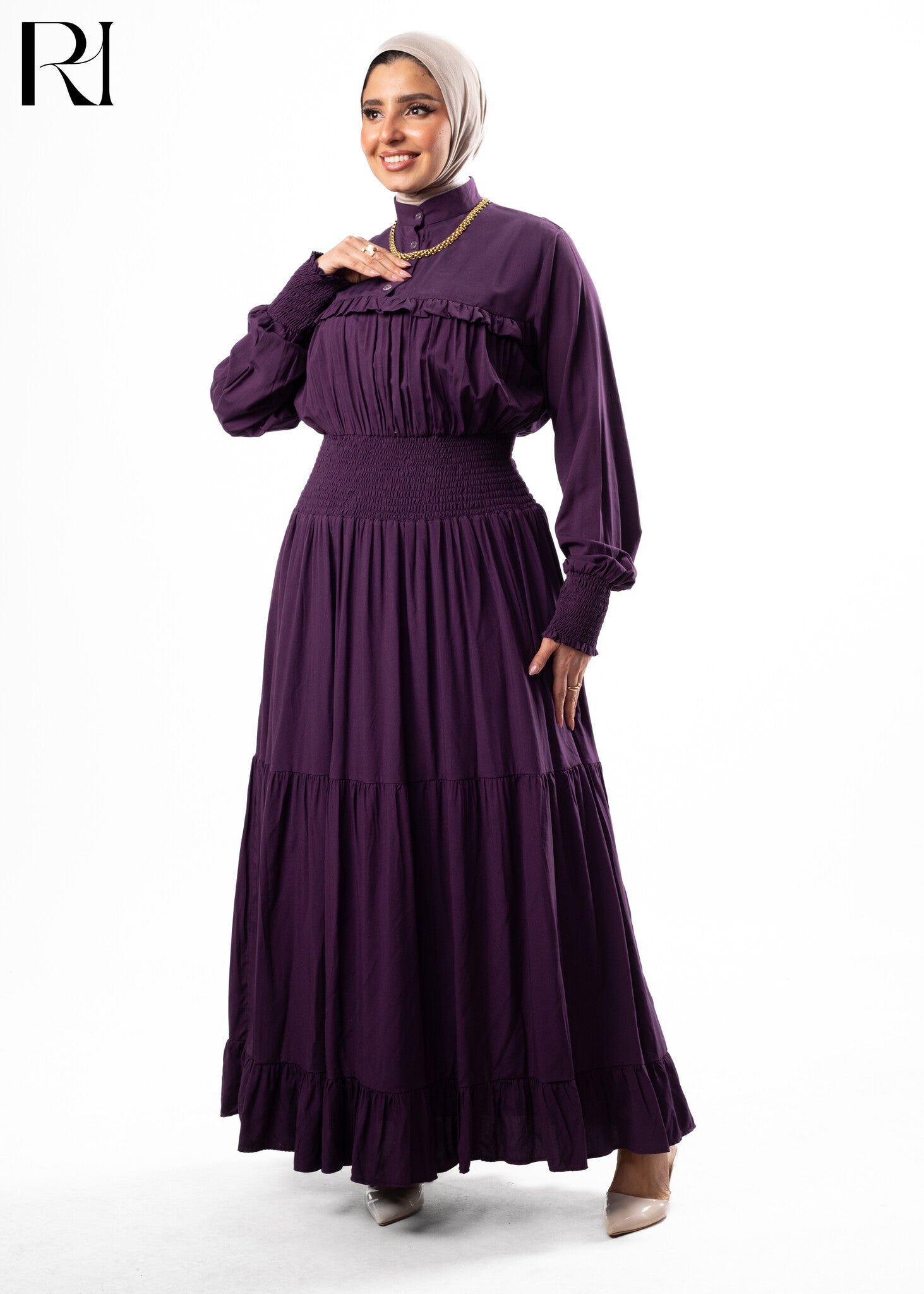 Woman wearing a purple dress with a hijab on a white background