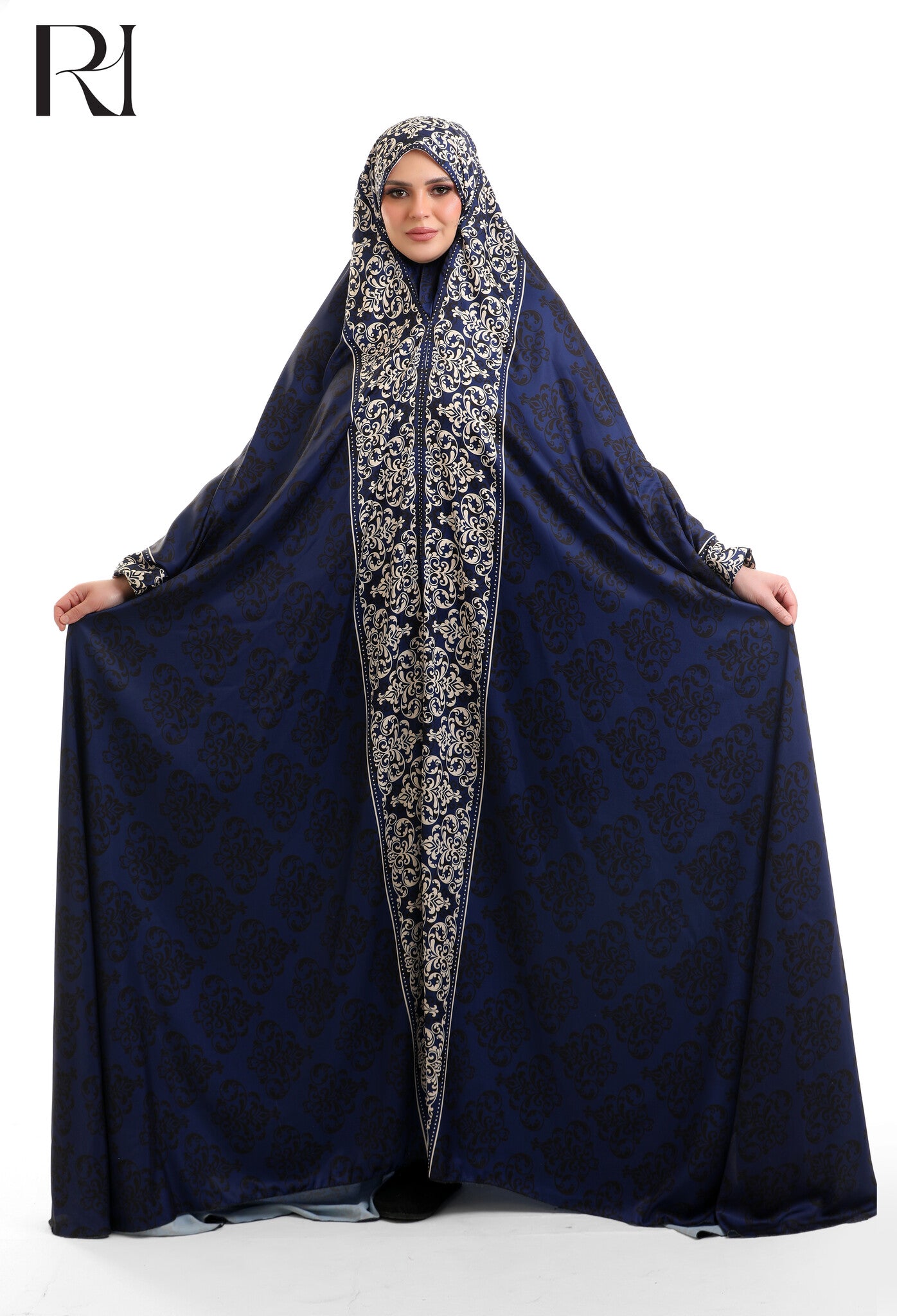 Woman wearing a navy blue abaya with intricate white embroidery on a white background