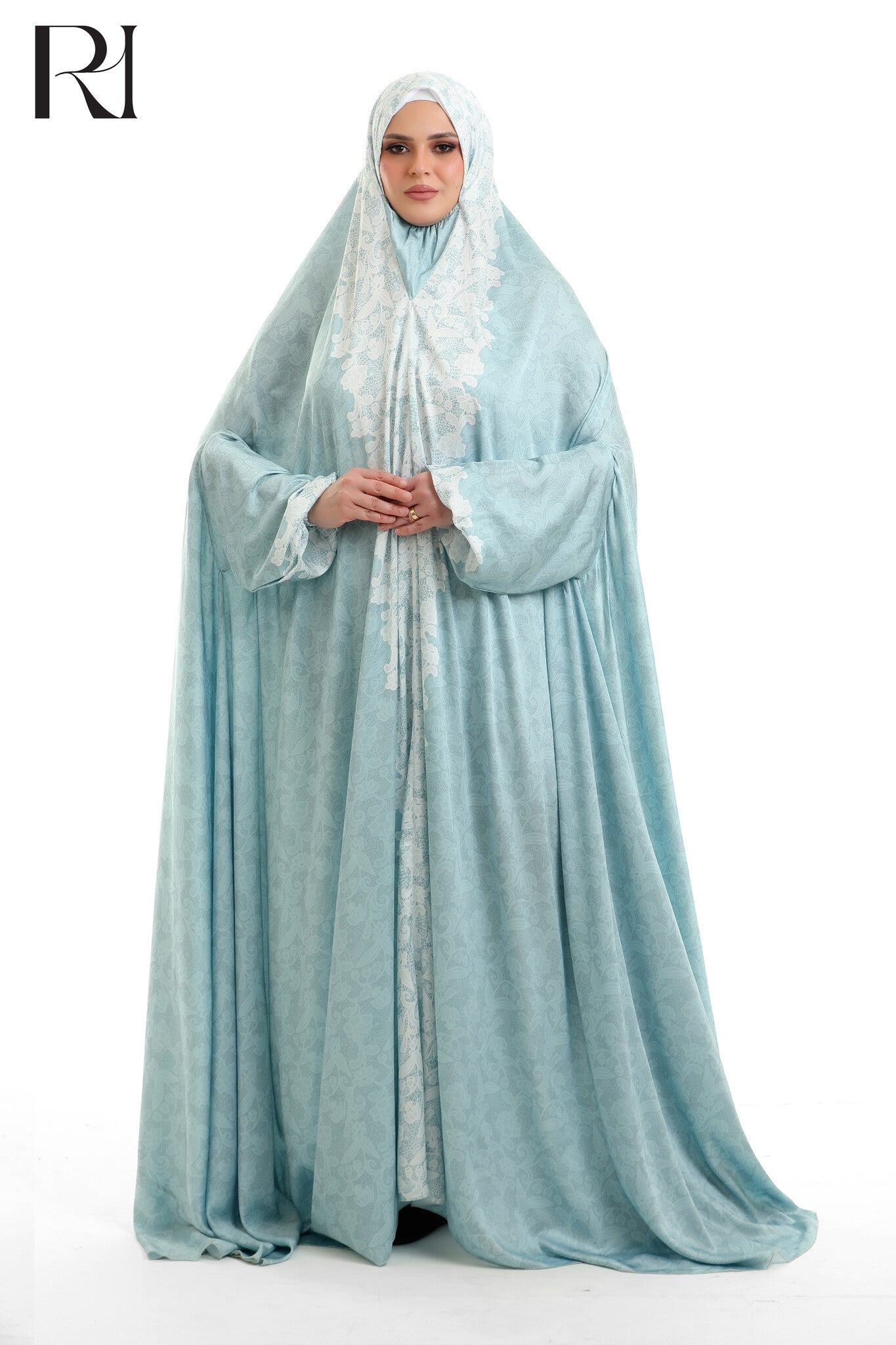 Woman wearing a light blue abaya with a matching hijab on a white background