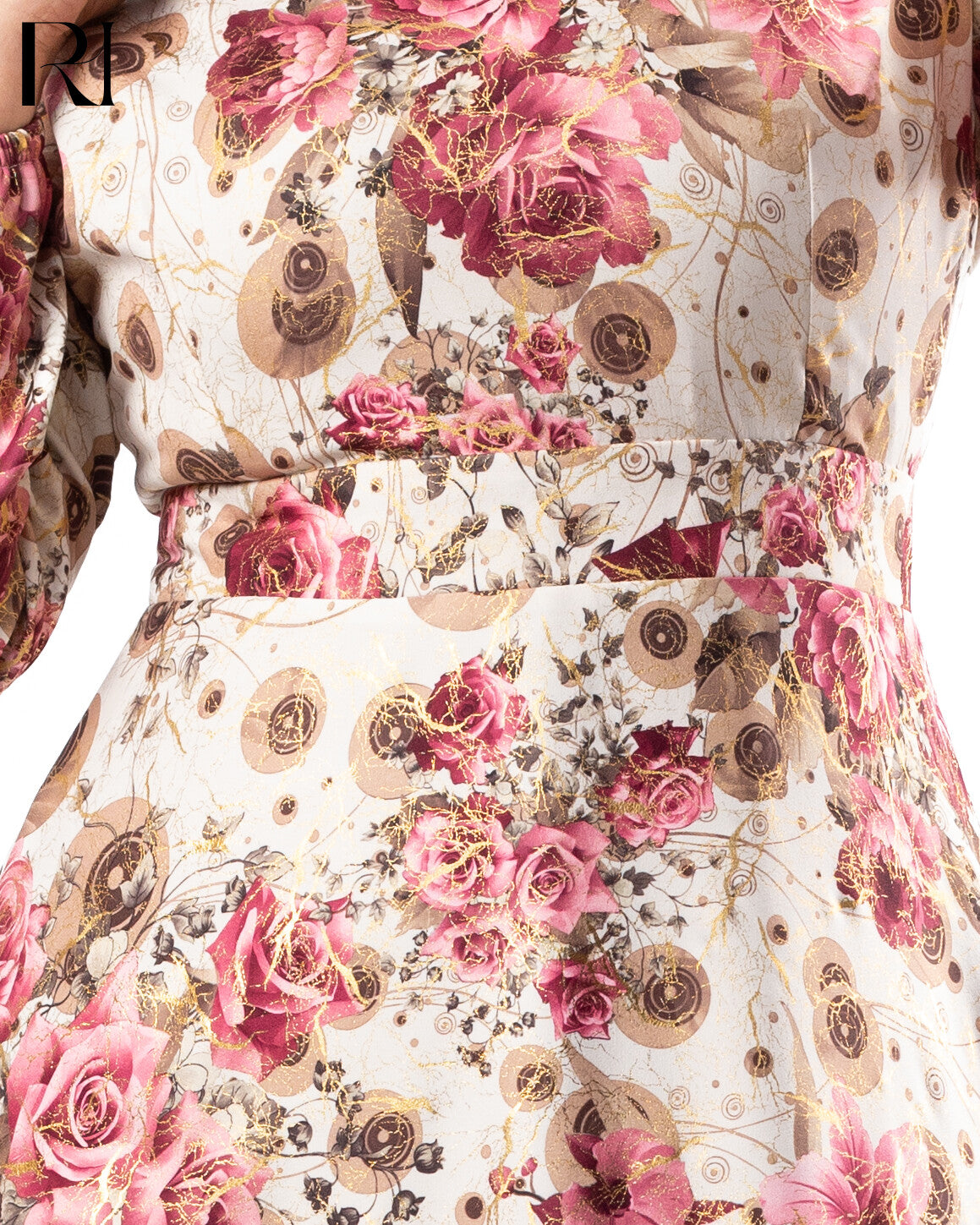 Close-up of a floral dress with pink roses and gold accents on a white background